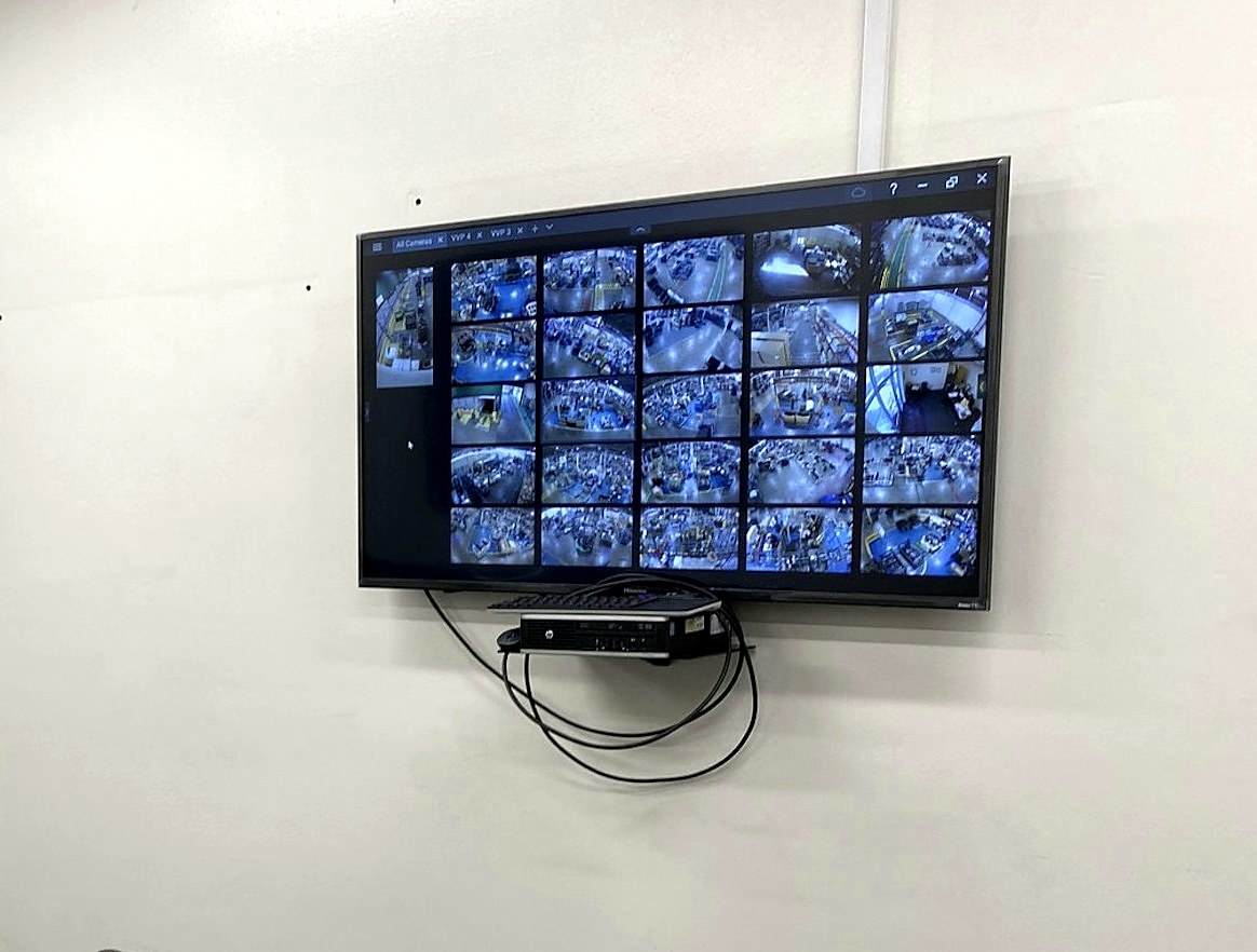 Live 12-camera surveillance monitor covering a Sterling Heights, Michigan warehouse and production floor