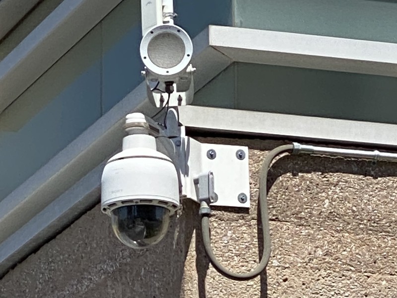 Commercial exterior PTZ dome security camera wall-mounted on a building, installed by Michigan Security Systems in Michigan