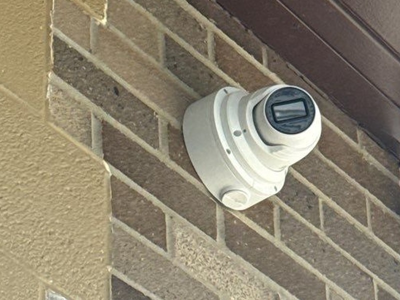 Hanwha Wisenet turret security camera mounted on a commercial brick exterior, installed by Michigan Security Systems in Michigan