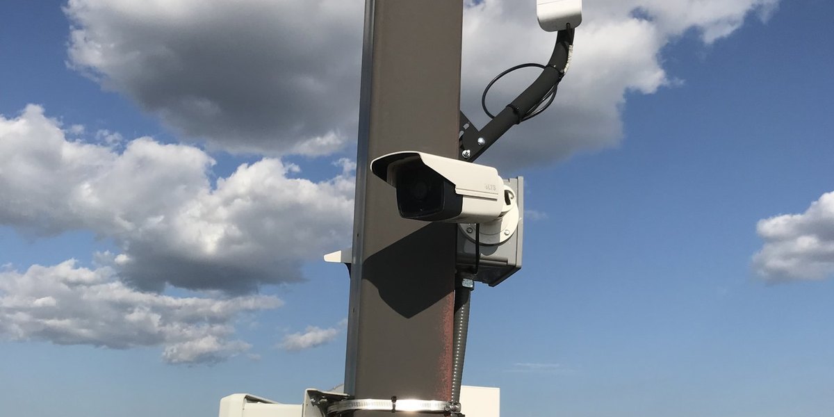 Pole-mounted security camera covering a car dealership lot in Michigan, installed by Michigan Security Systems