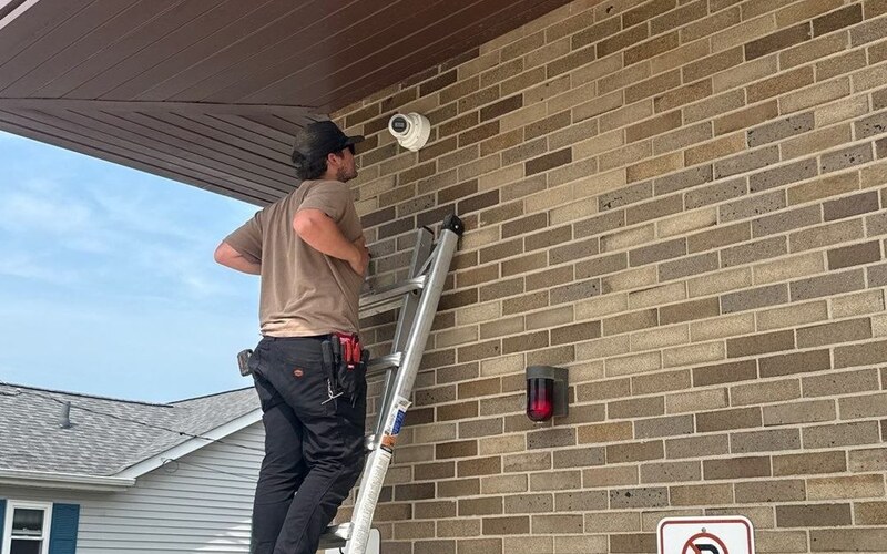 Michigan Security Systems technician installing a security camera at an industrial facility