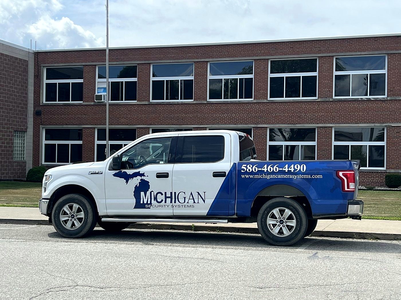 Michigan Security Systems branded service truck at a commercial building — Michigan Security Systems