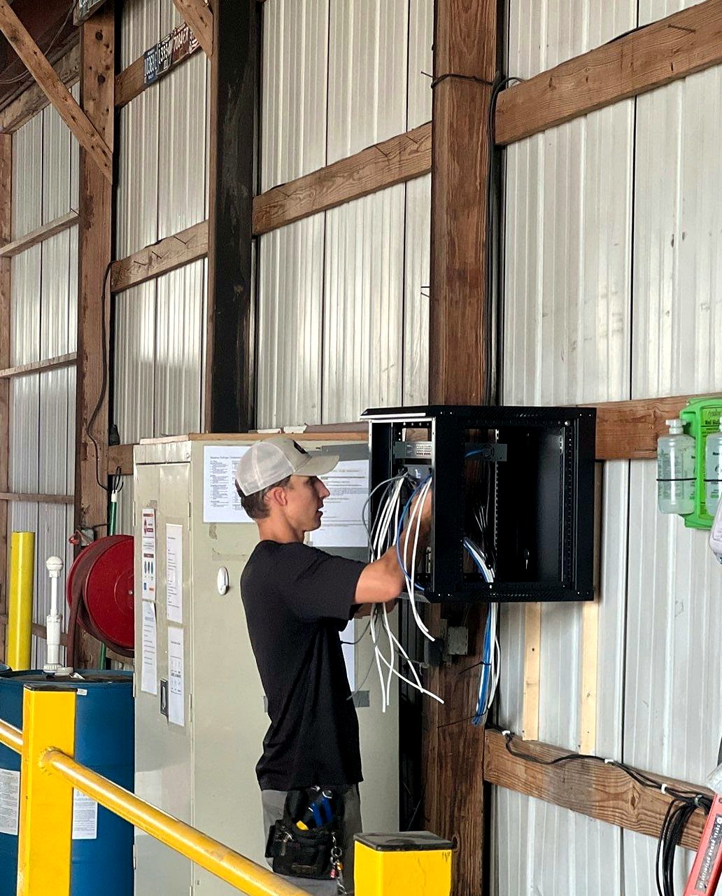 Michigan Security Systems technician installing IDF network rack with Cat6 cabling