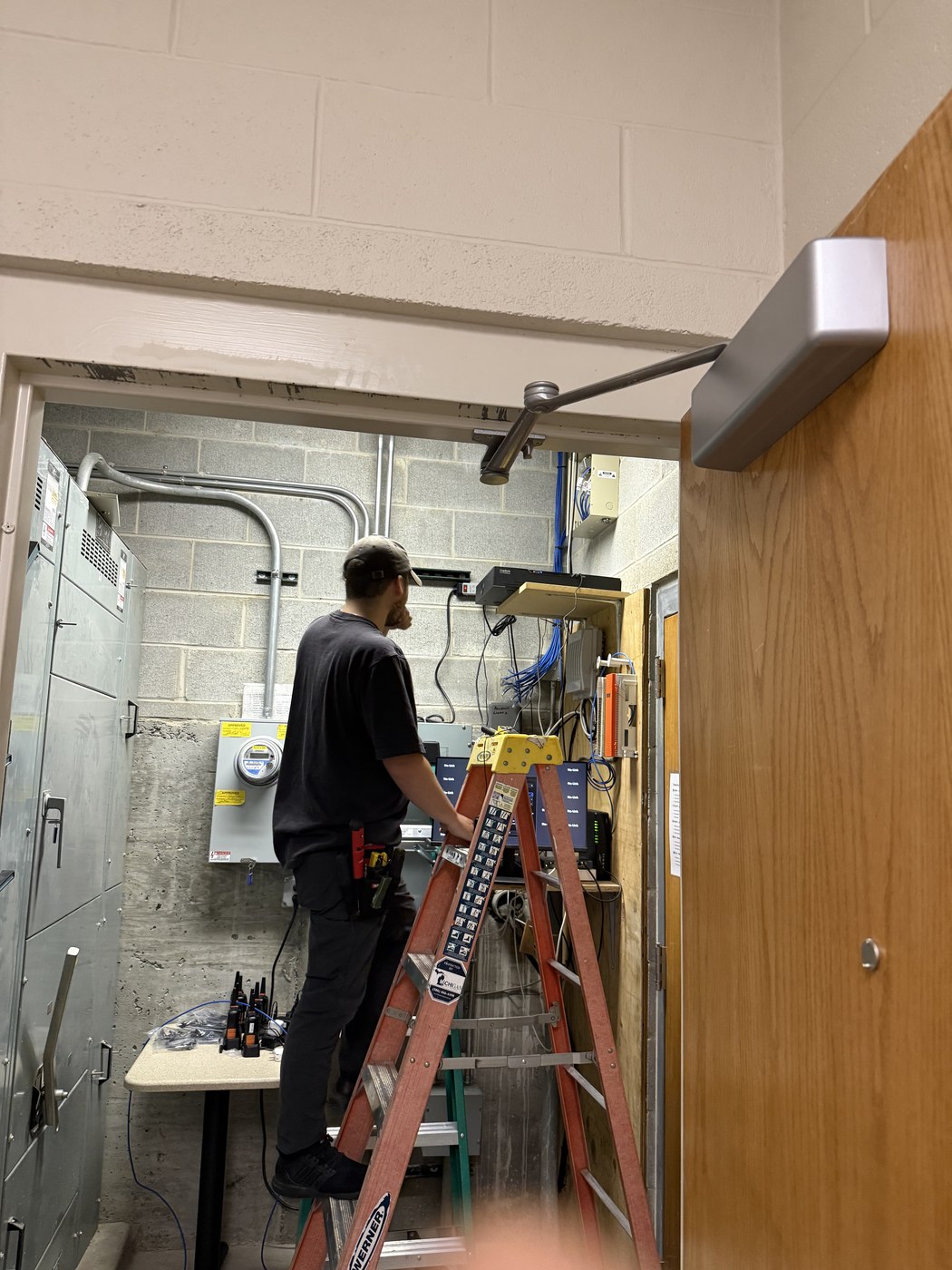 Michigan Security Systems technician installing structured cabling in an electrical closet at a Michigan business